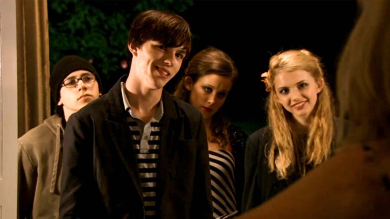 Four young teens standing in a doorway in a scene from Skins.