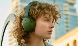 Woman wearing Bose QuietComfort Headphones in green.