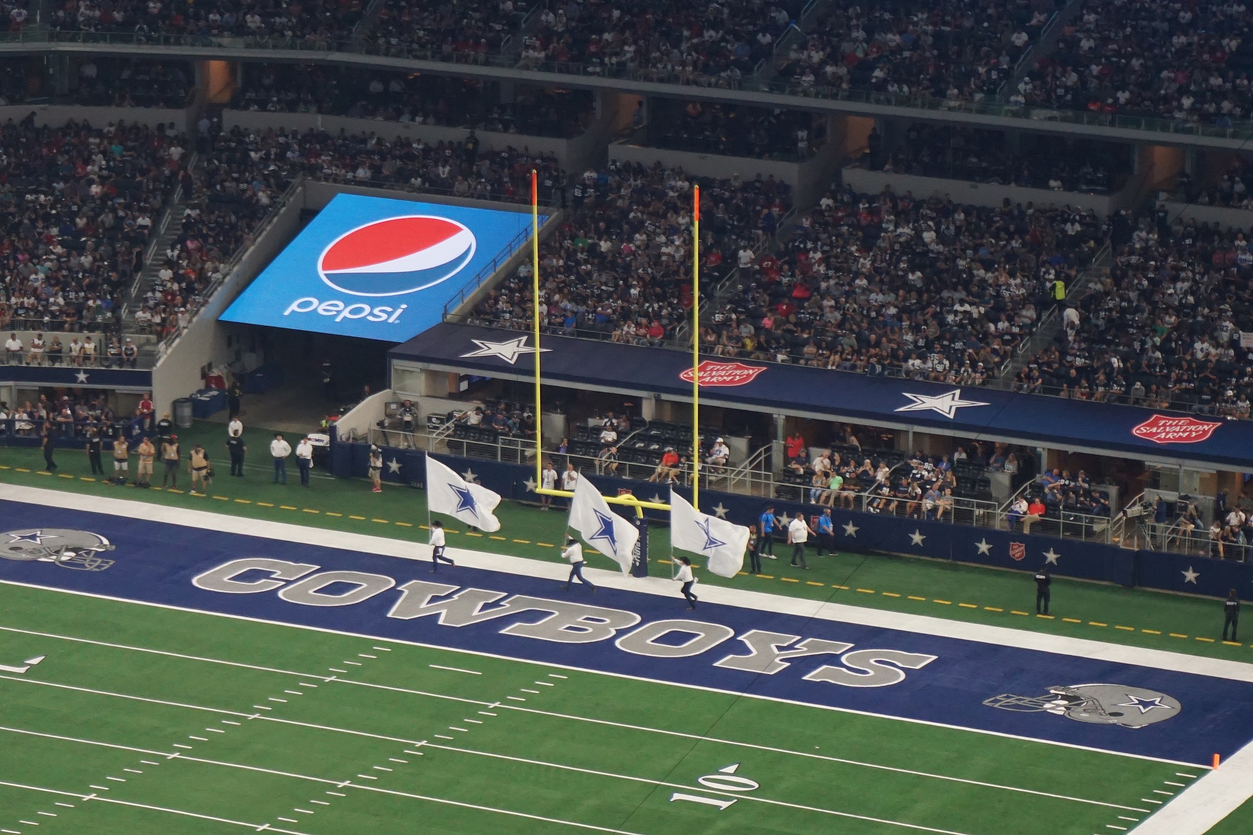 Cheerleaders run across the endzone in Cowboys' Stadium.