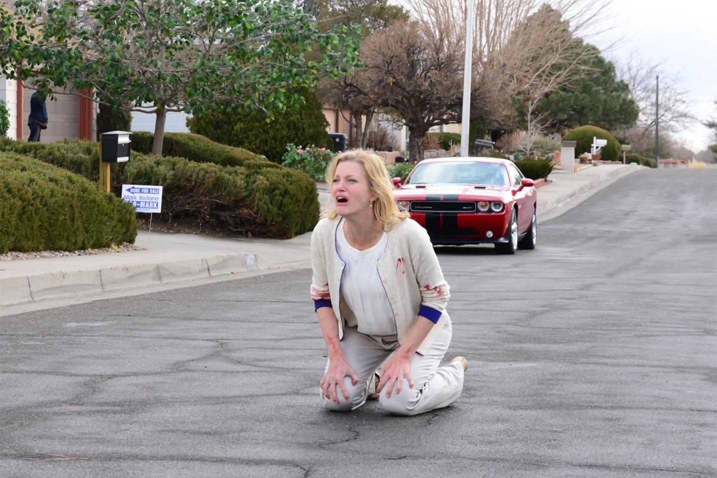 Skyler White se ajoelha na rua na 5ª temporada de Breaking Bad.