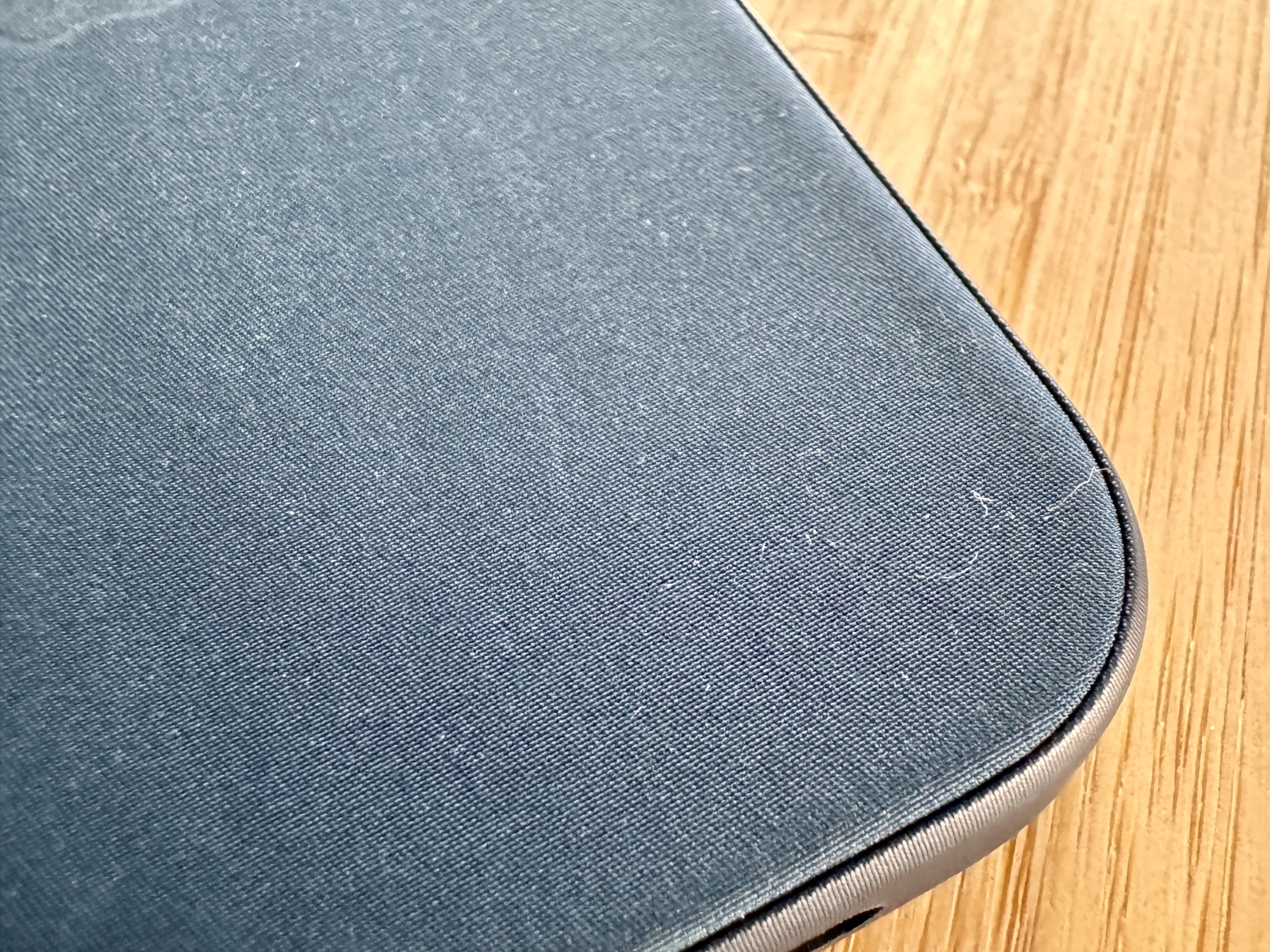 Macro of Pacific Blue FineWoven case with some lint and scratches.