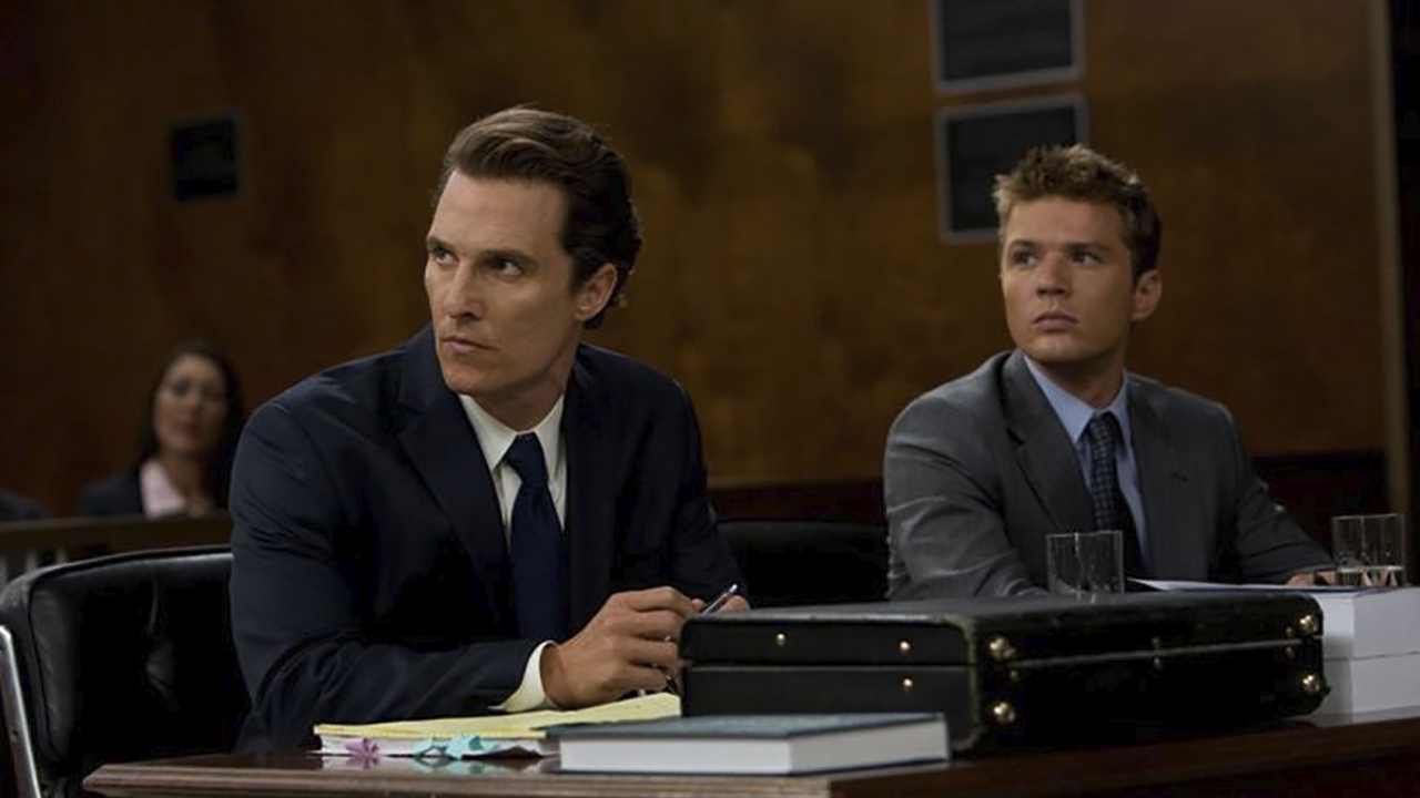 Un abogado y un cliente se sientan en el tribunal en una escena de la película El abogado de Lincoln.
