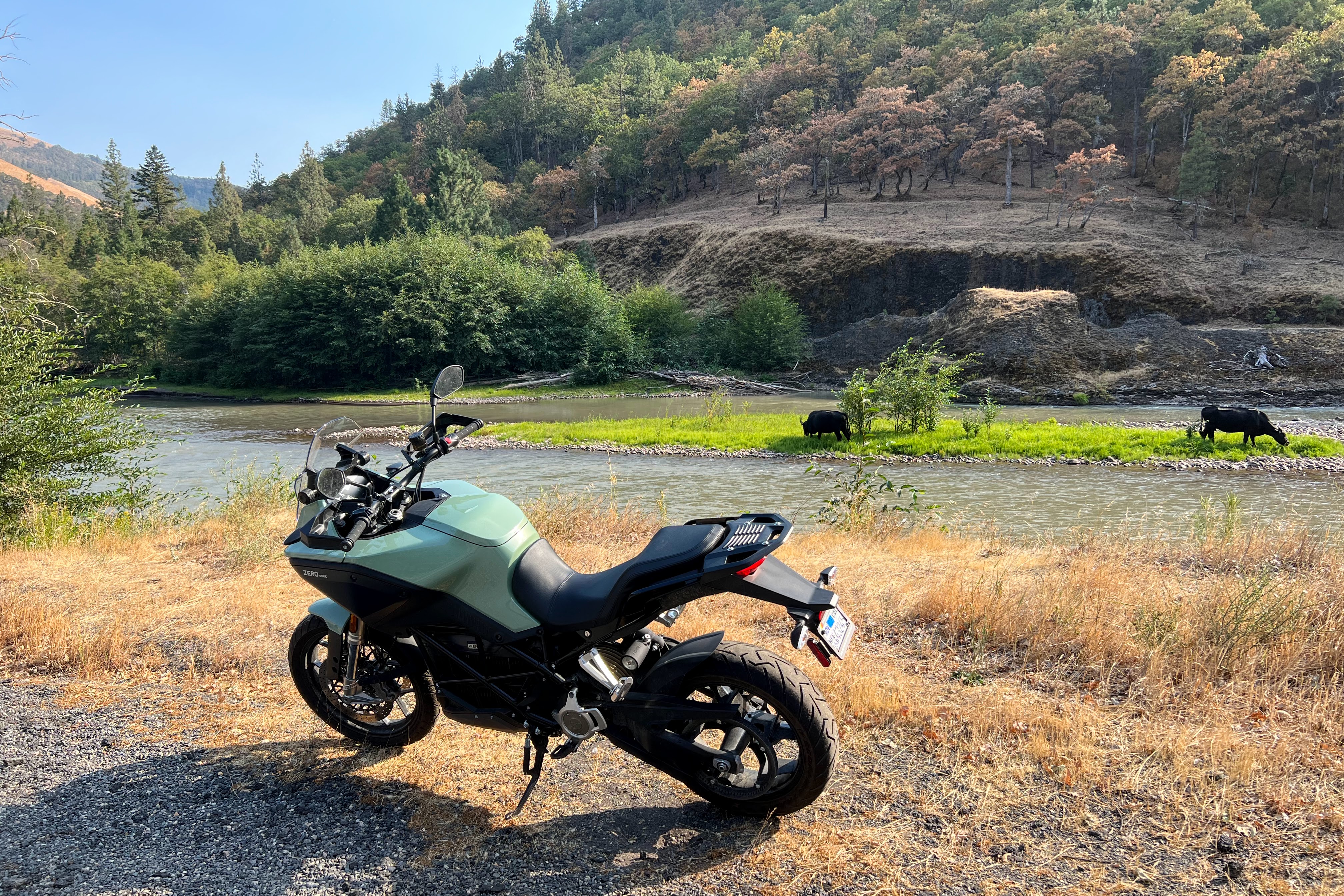 Uma motocicleta elétrica Zero DSR-X 2023 está parada ao lado do rio Klickitat, em Washington.