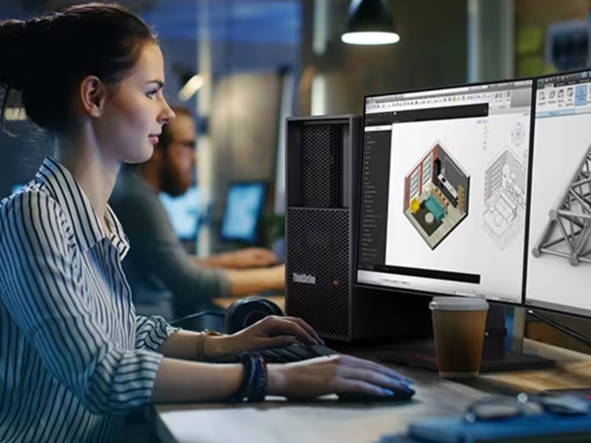 Una mujer trabaja en la estación de trabajo en torre Lenovo ThinkStation P3 junto a dos monitores.