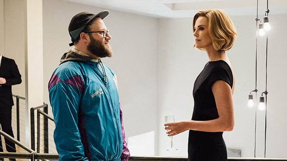 Seth Rogen y Charlize Theron en plano largo.