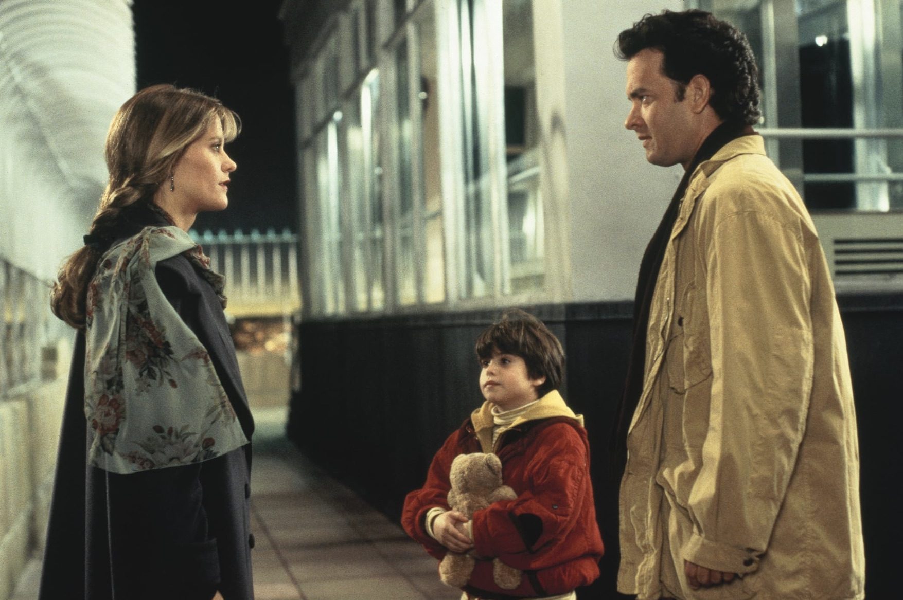 Un hombre junto a su hijo se para frente a una mujer en Sleepless in Seattle.