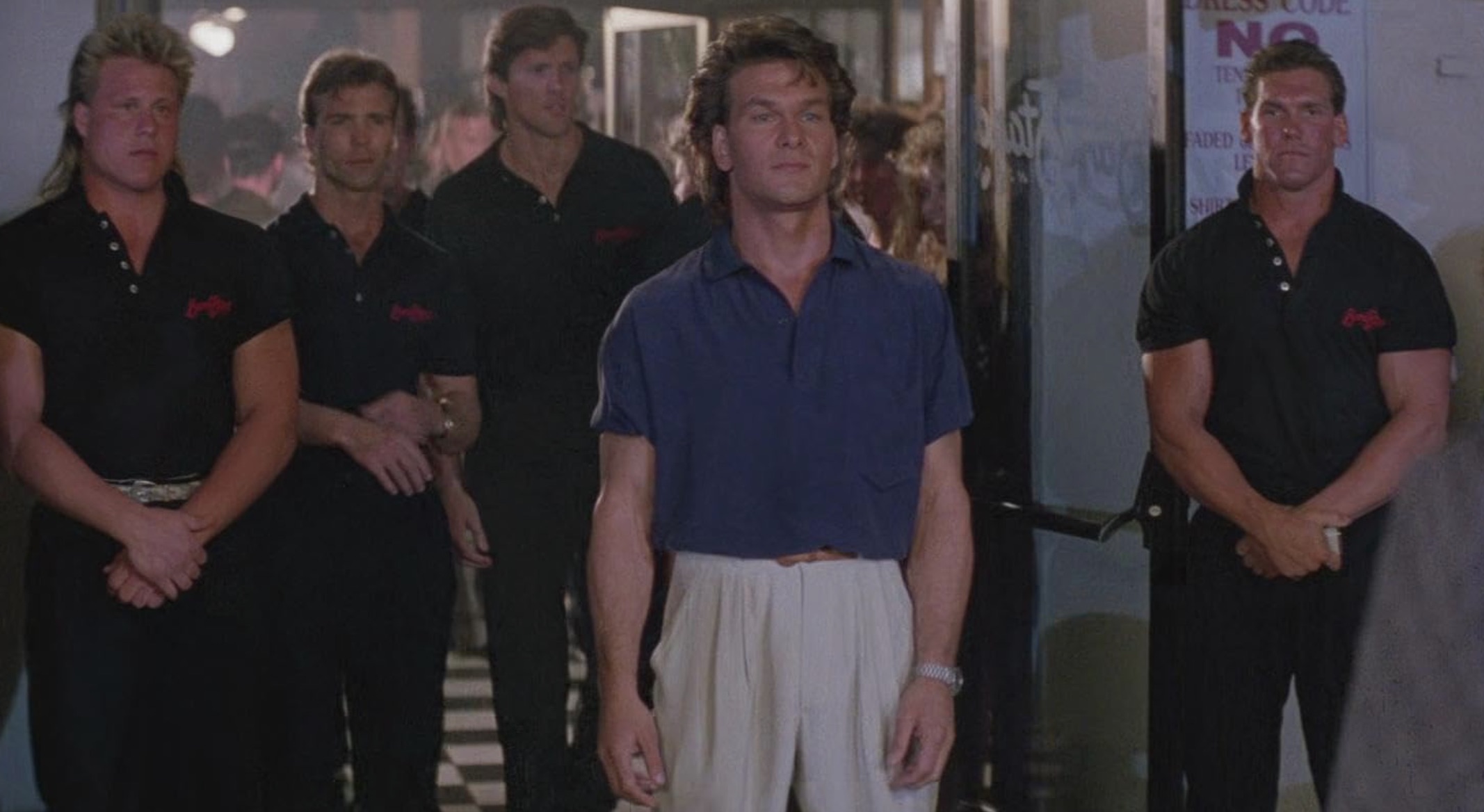 Patrick Swayze steht vor Sicherheitsleuten im Road House.