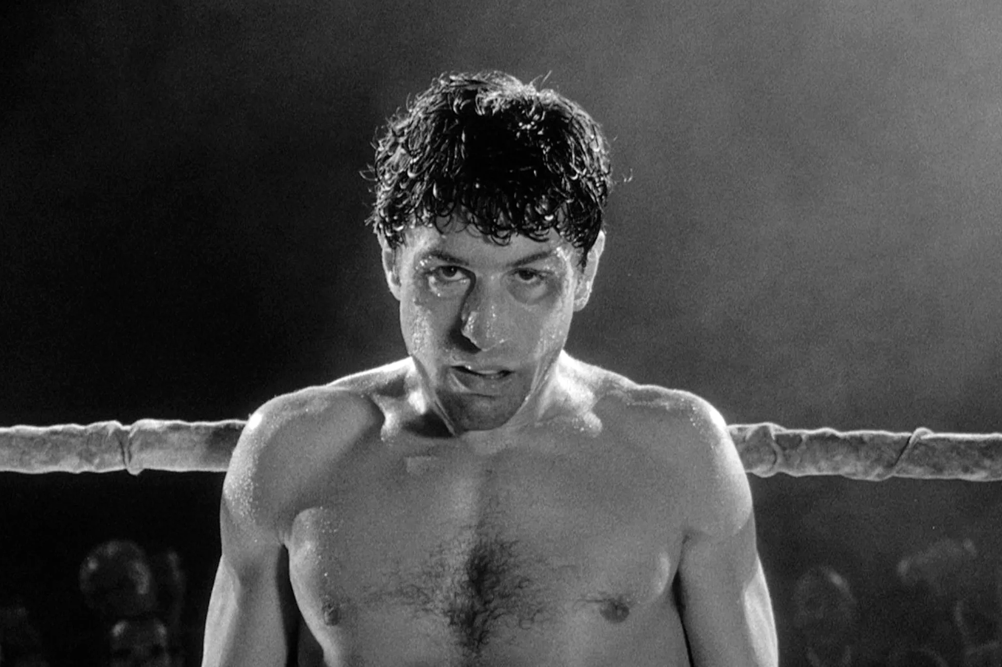 Robert De Niro se tient près d’une corde sur un ring de boxe dans Raging Bull.