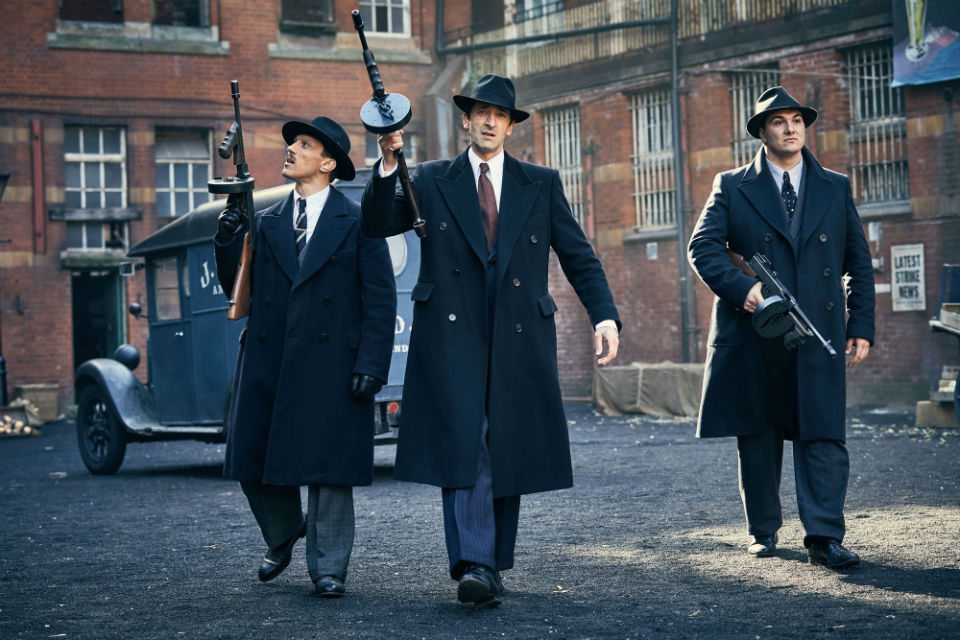 Adrien Brody tenant une arme dans Peaky Blinders.