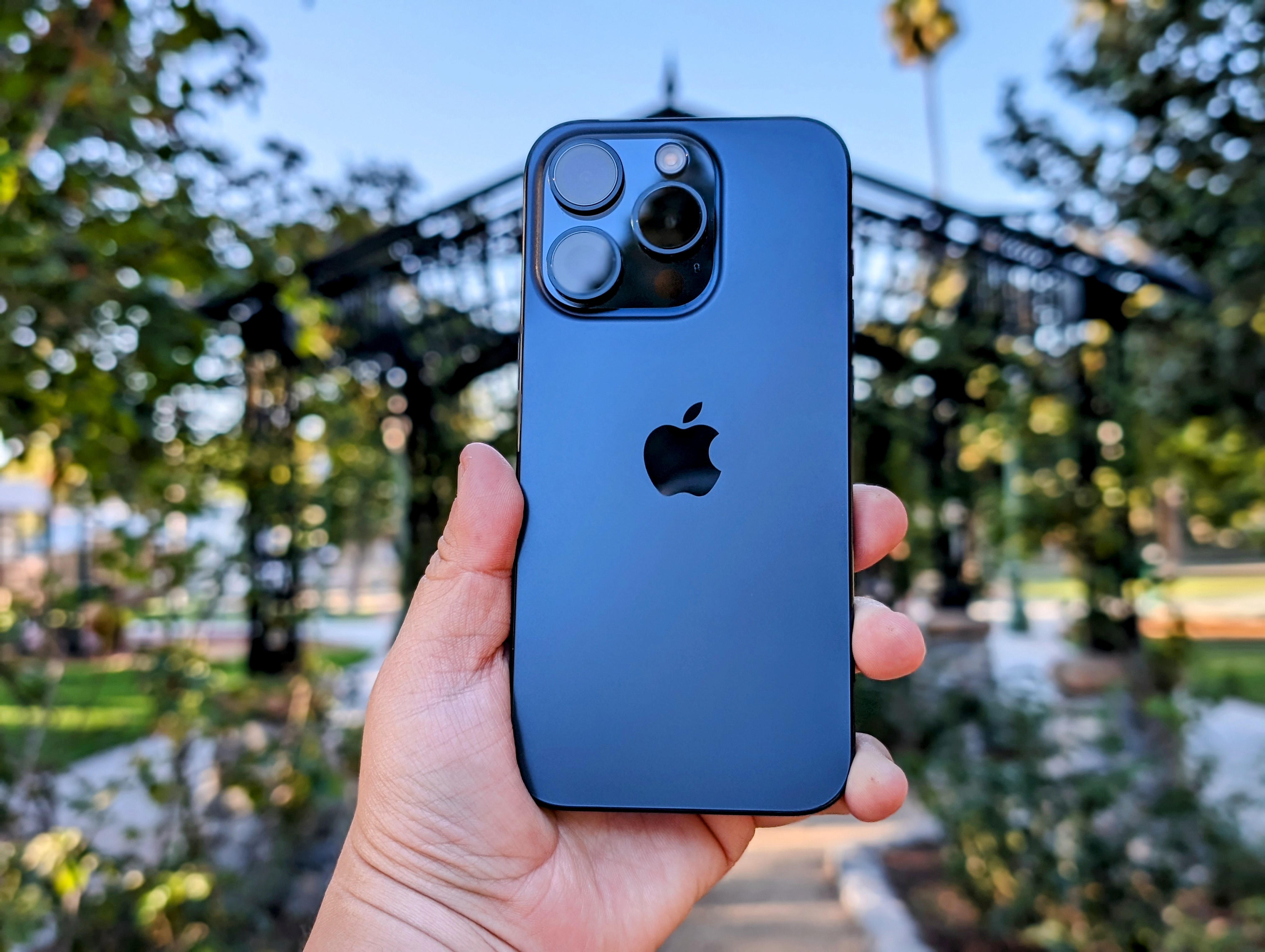 iPhone 15 Pro en titane bleu à la main.