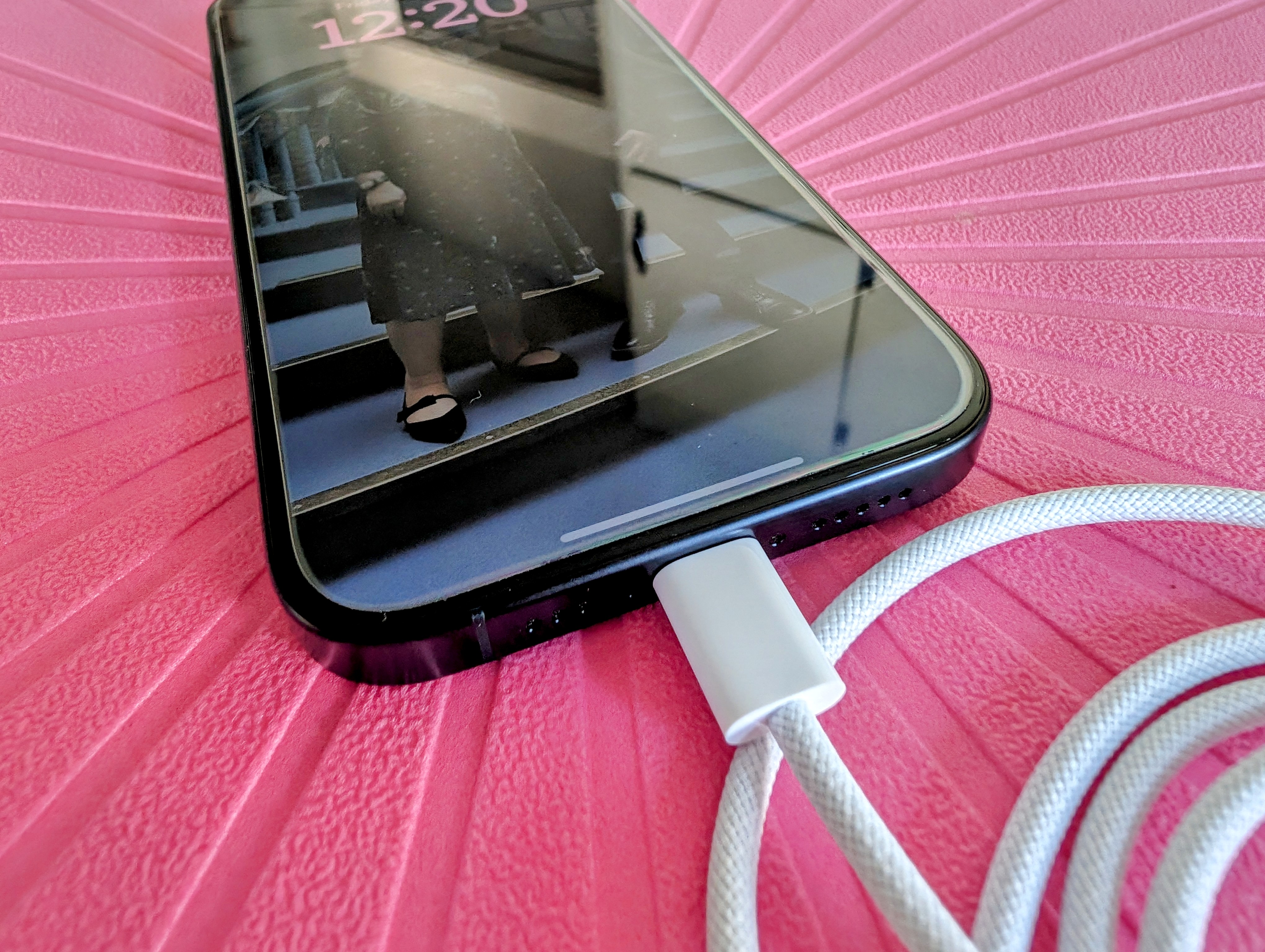 蓝色钛 iPhone 15 Pro 及其随附的 USB-C 数据线。