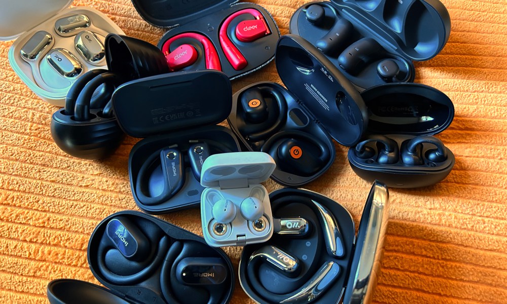 A collection of open-ear earbuds in their charging cases.