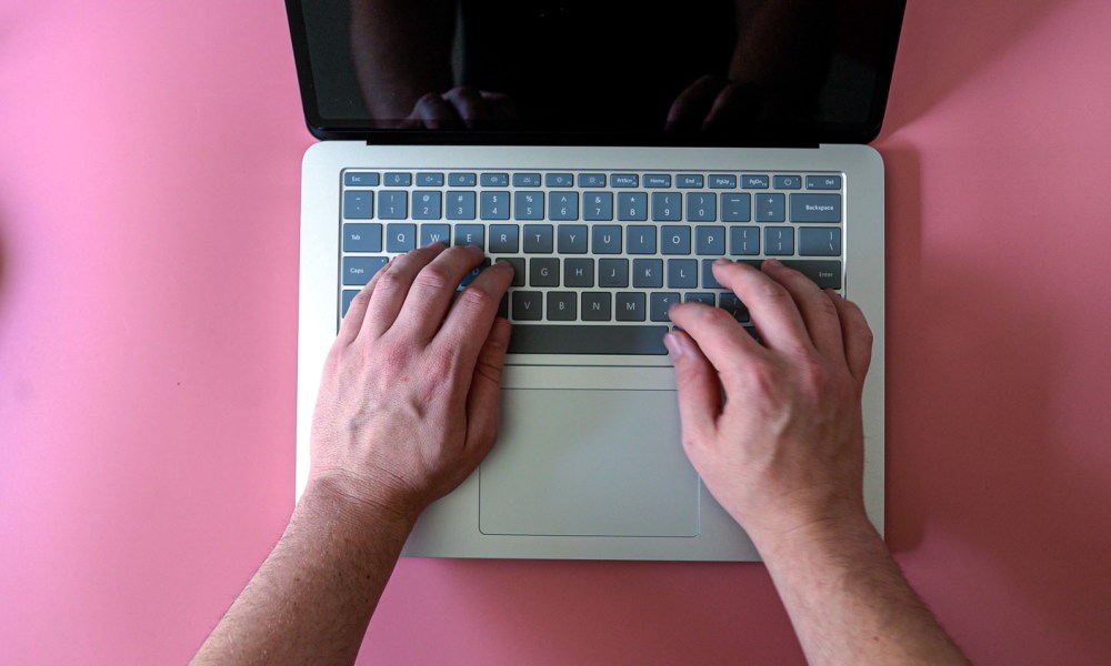 Overhead view of someone typing on a Surface laptop.