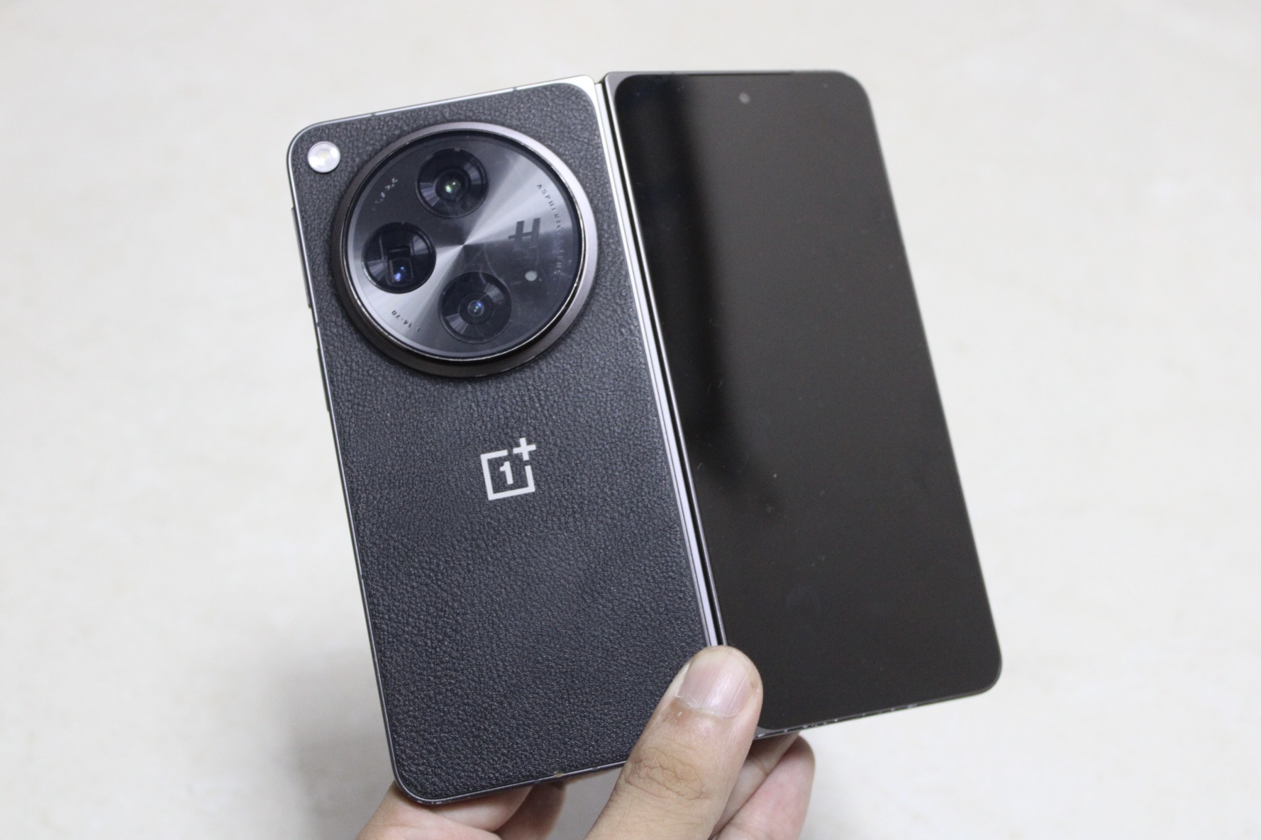 OnePlus Terbuka dari belakang, dalam genggaman dan terlipat kurang dari setengahnya.