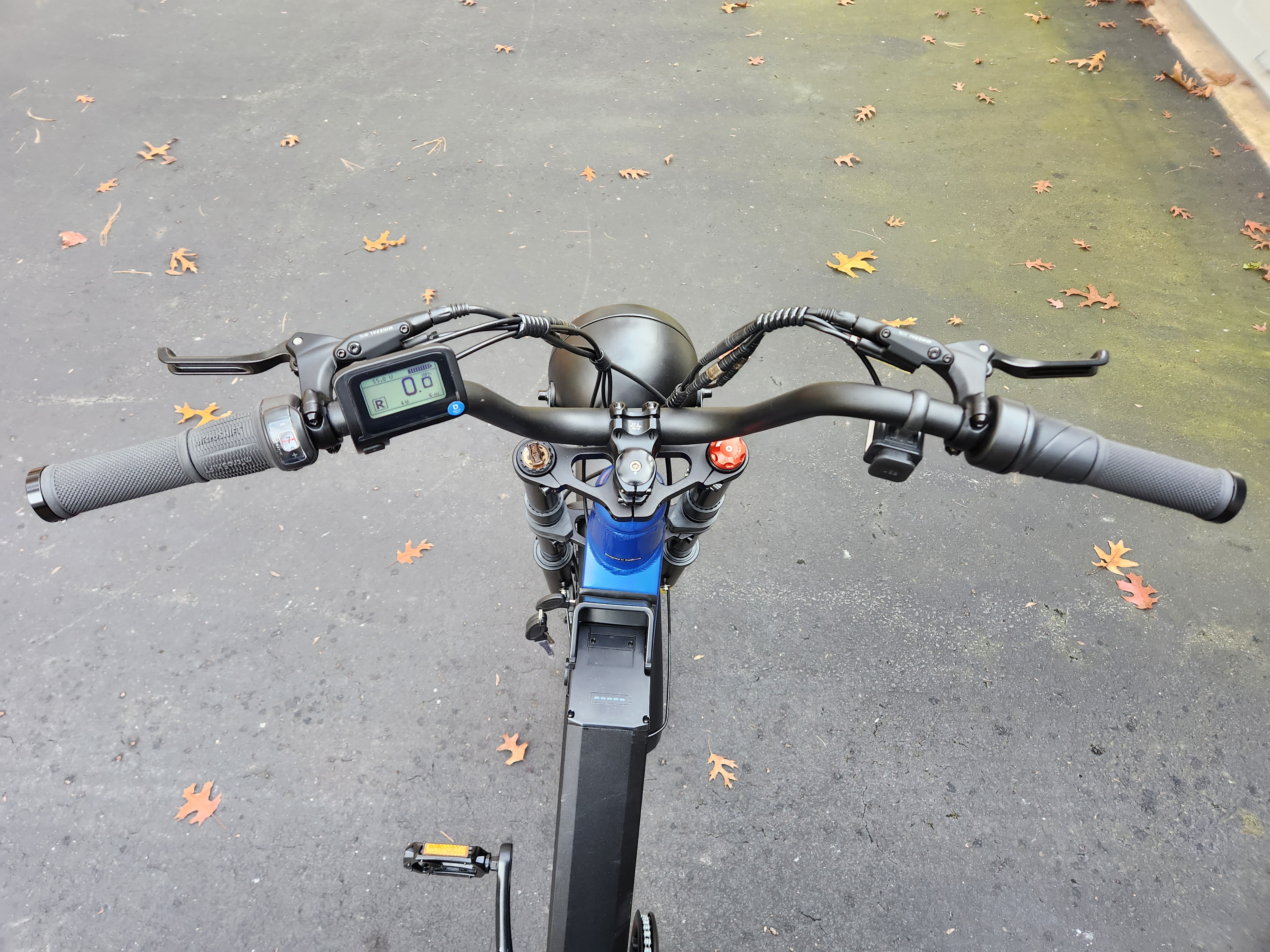 Juiced Bikes Scorpion X2 uncluttered handlebars shown with paved asphalt background.