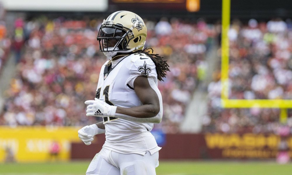 Alvin Kamara jogs on a football field.