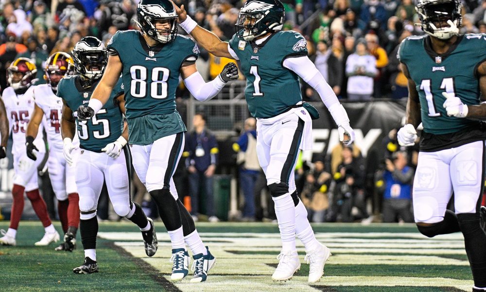 Three Eagles players celebrate in the end zone.