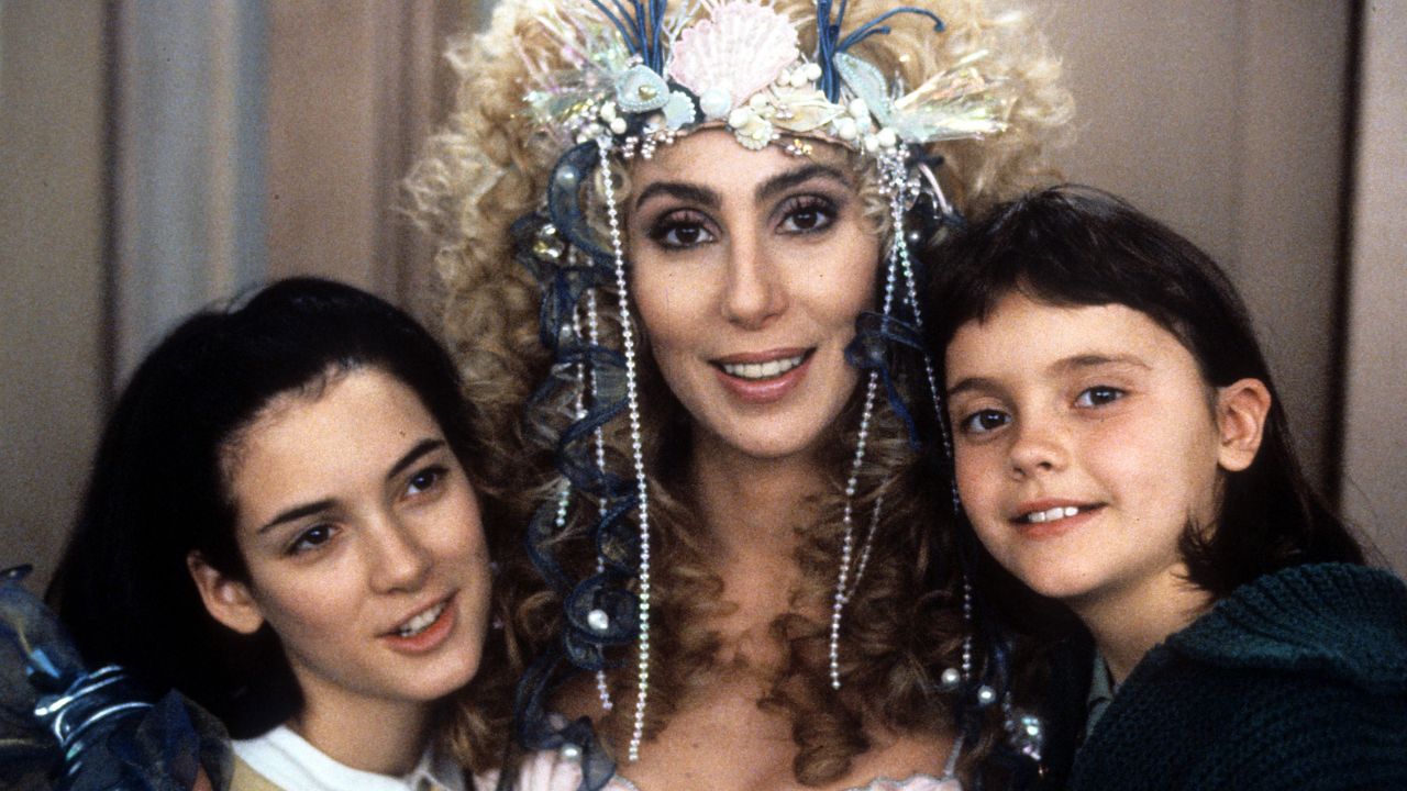 Winona Ryder, Cher et Christina Ricci dans le rôle de Charlotte, Rachel et Kate Flax posant pour une photo et souriant dans le film Mermaids de 1990.