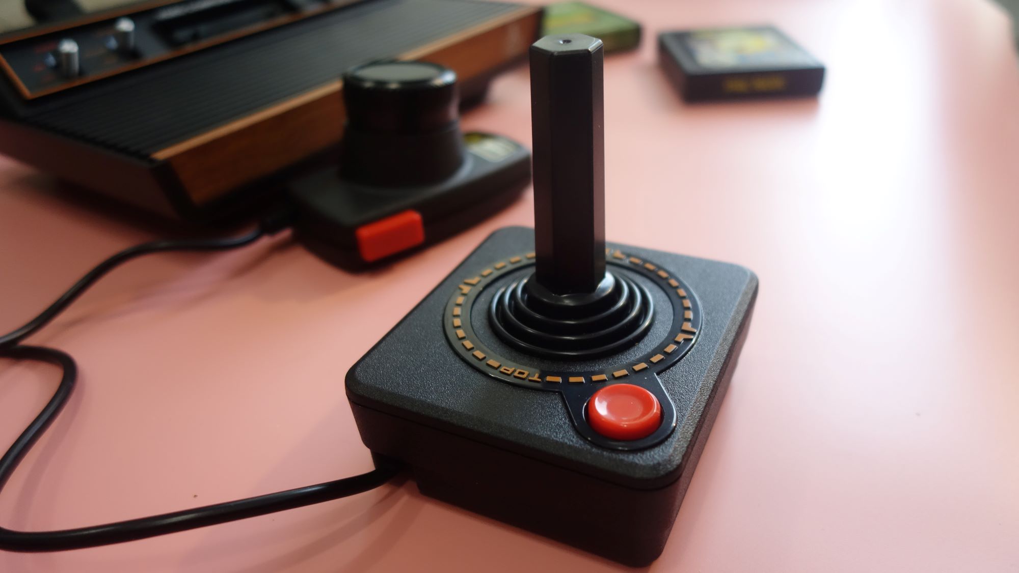 Un joystick Atari 2600+ se encuentra sobre una mesa.
