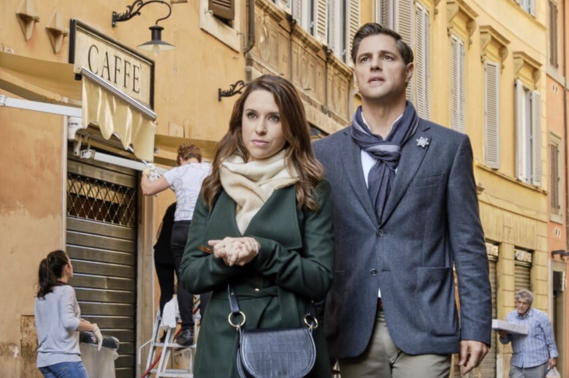 Um homem e uma mulher caminham por um beco em Roma.