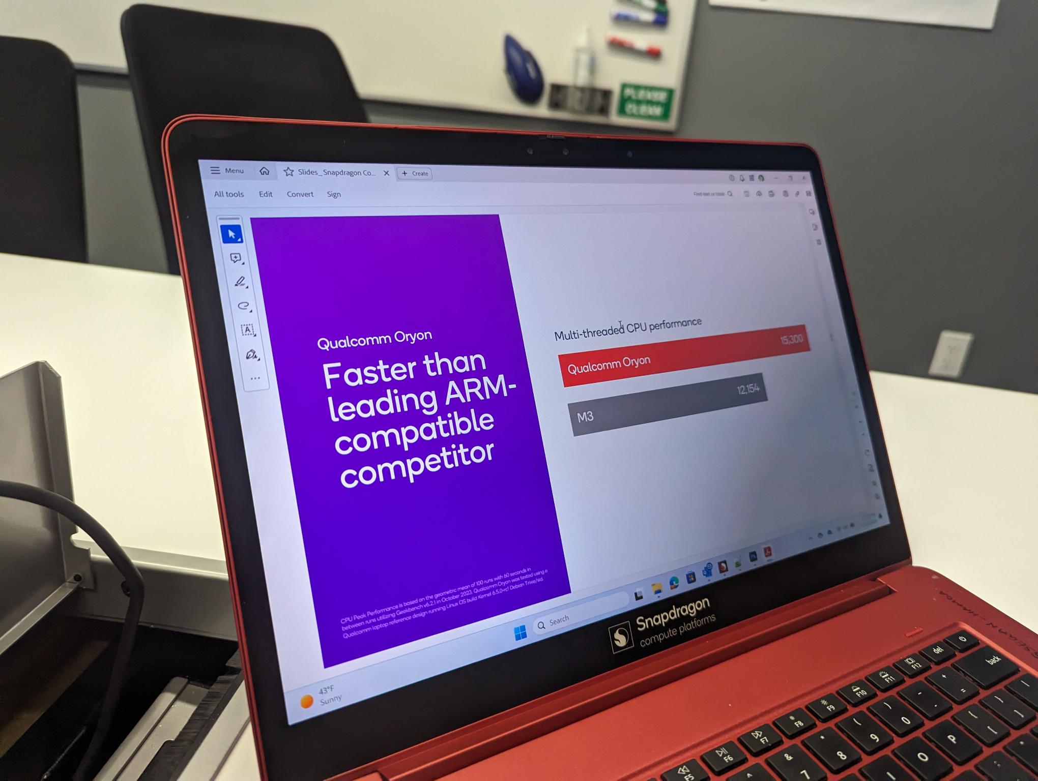 Una computadora portátil de demostración de Qualcomm con una diapositiva que muestra comparaciones de rendimiento.
