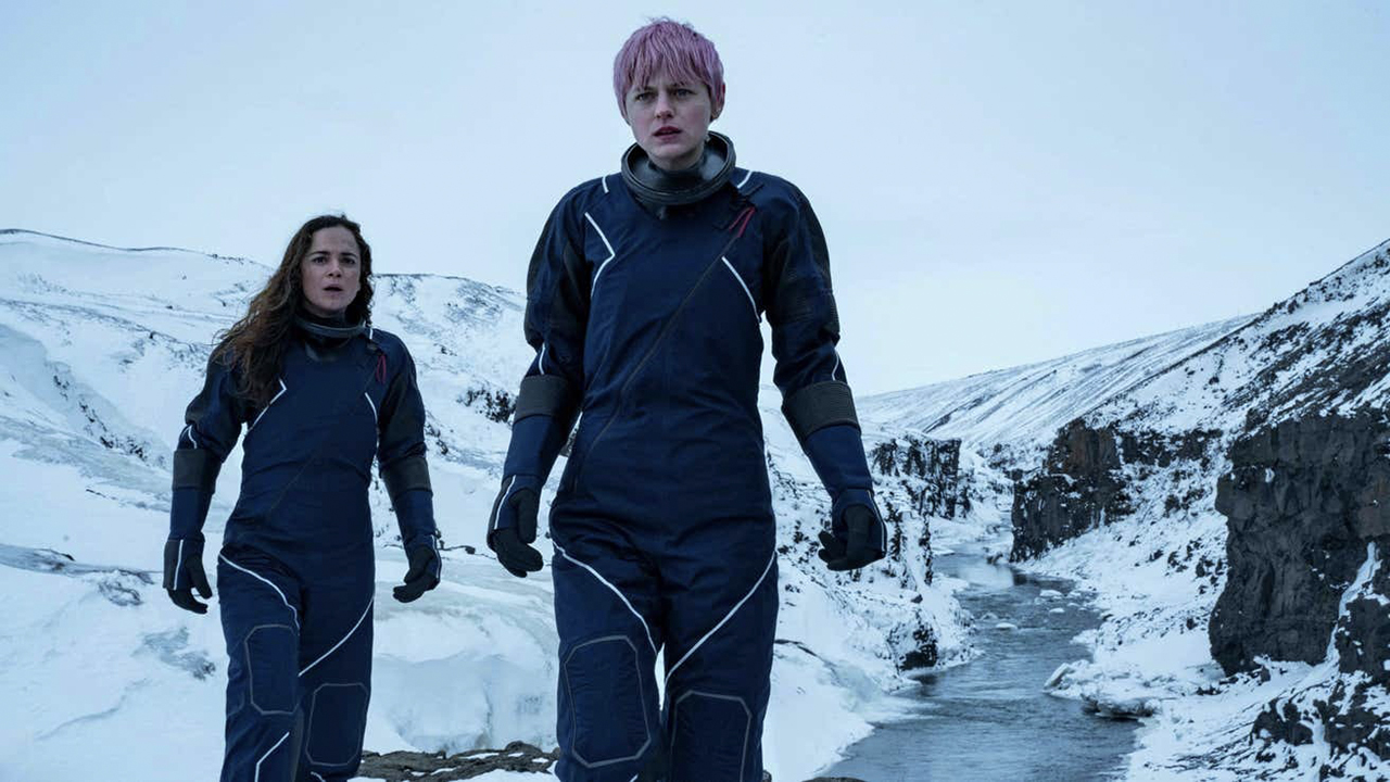 Darby y Sian caminando en trajes de nieve con una escena invernal de Un asesinato en el fin del mundo.