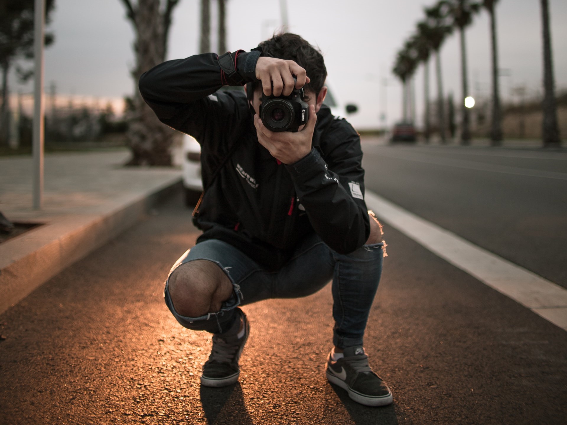 Homem tirando foto com câmera na estrada.