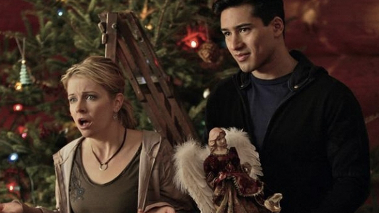 Melissa Joan Hart und Mario Lopez an einem Weihnachtsbaum in „Holiday in Handschellen“.