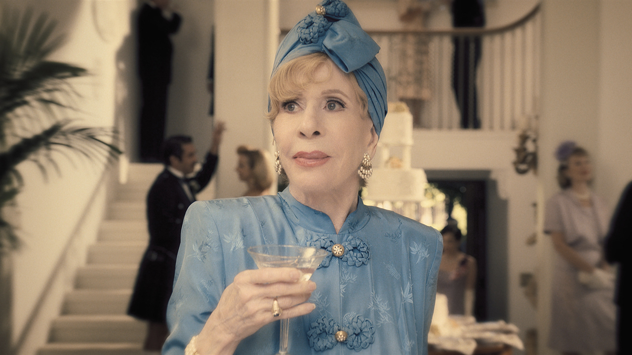 Carol Burnett hält einen Drink in der Hand und verkleidet sich in einer Szene aus Palm Royale auf Apple TV+.