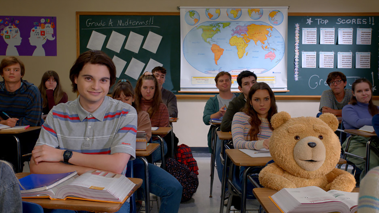 John and Ted sitting next to one another in a classroom from the Peacock prequel series Ted.