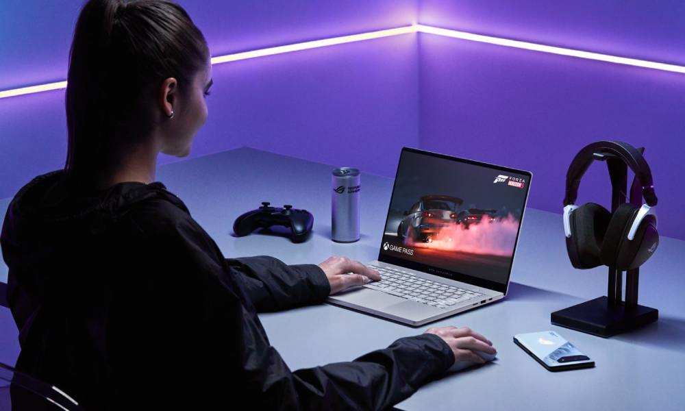 A person using the Asus ROG Zephyrus G14 laptop on a desk.