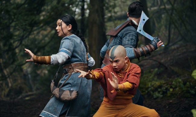 Three people including a young child are preparing to fight in a scene from Avatar: The Last Airbender on Netflix.