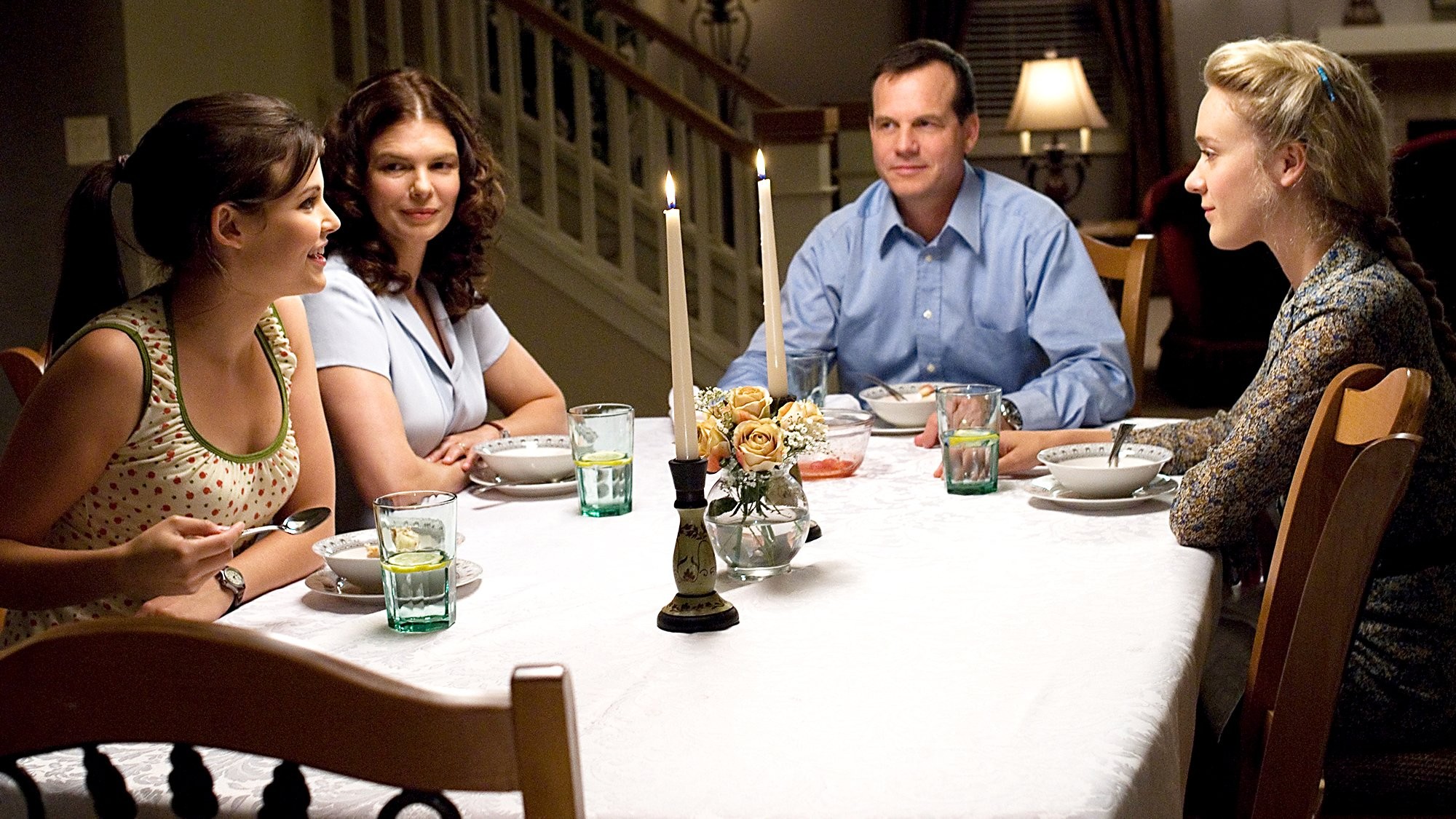 Une famille est assise à une table dans Big Love.