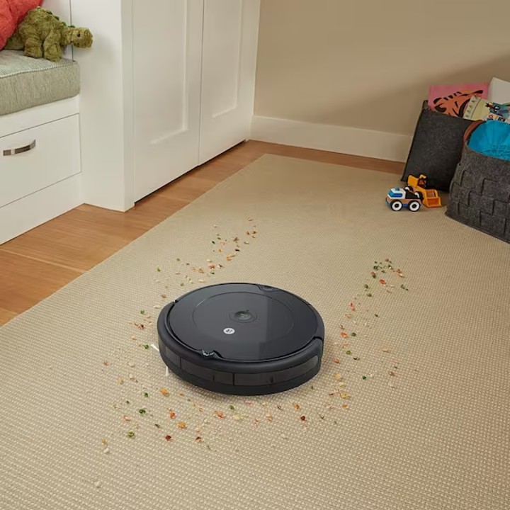 The iRobot Roomba 694 Robot Vacuum vacuums a messy floor.