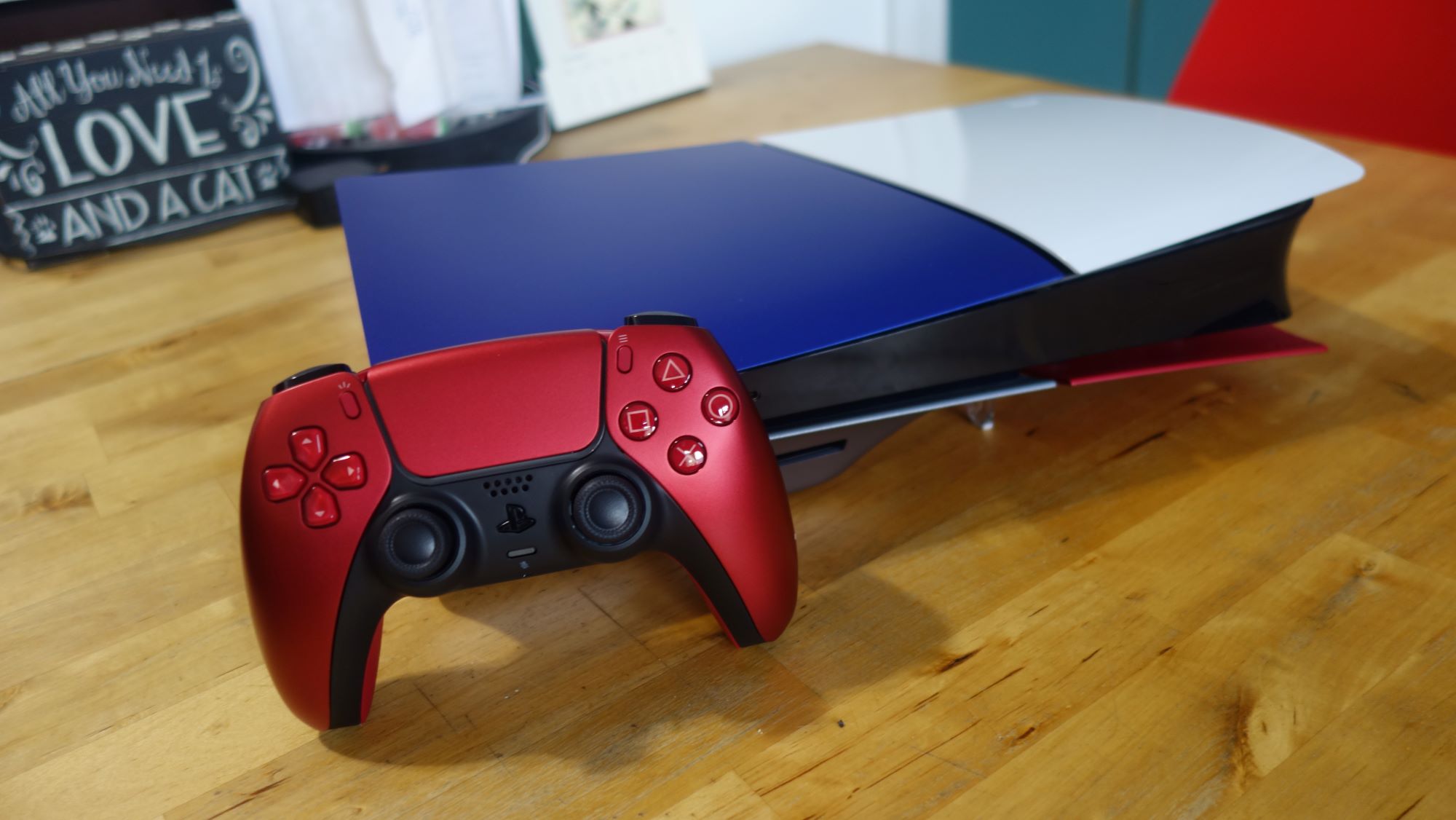 Eine PS5 Slim liegt auf einem Tisch mit verschiedenfarbigen Frontplatten.