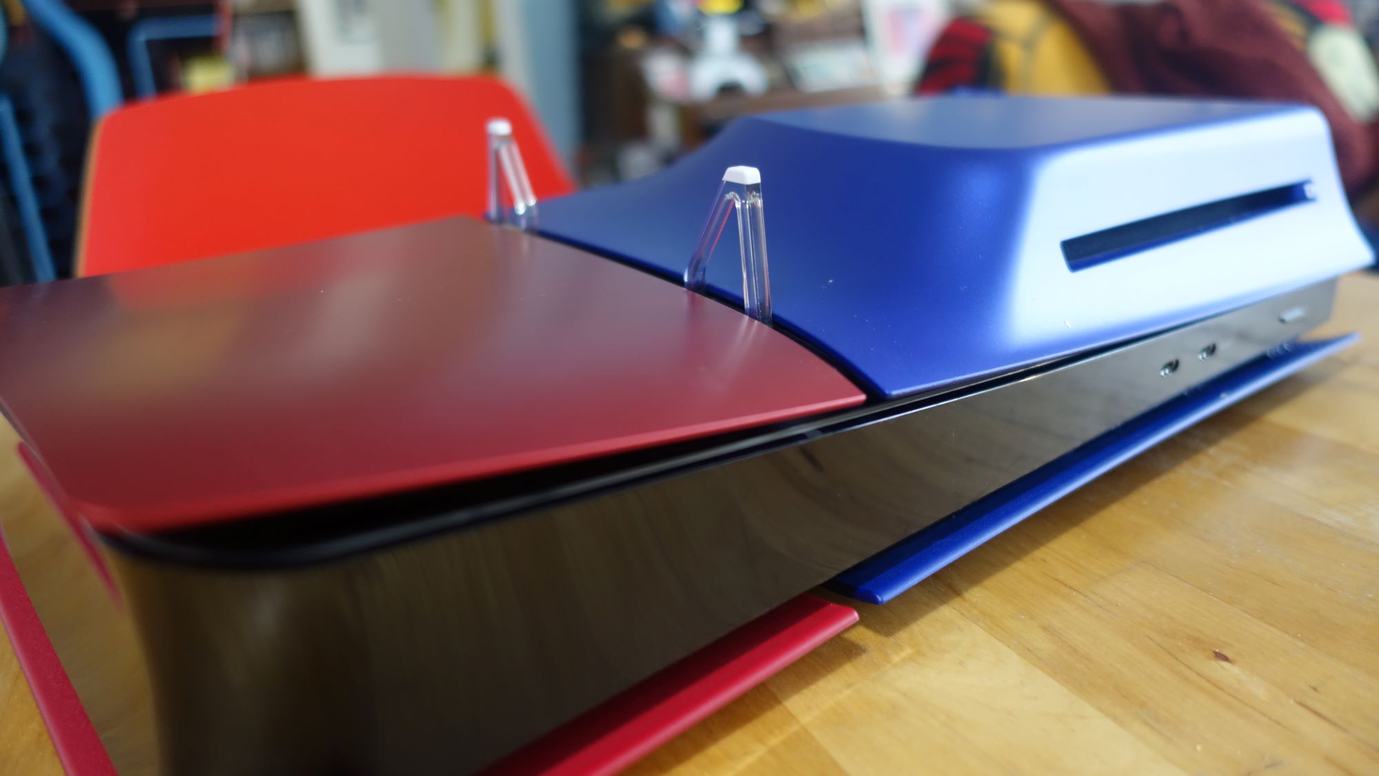 Une PS5 rouge et bleue est posée sur une table.