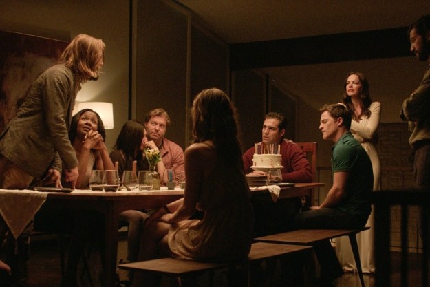 People sit at a table in The Invitation.