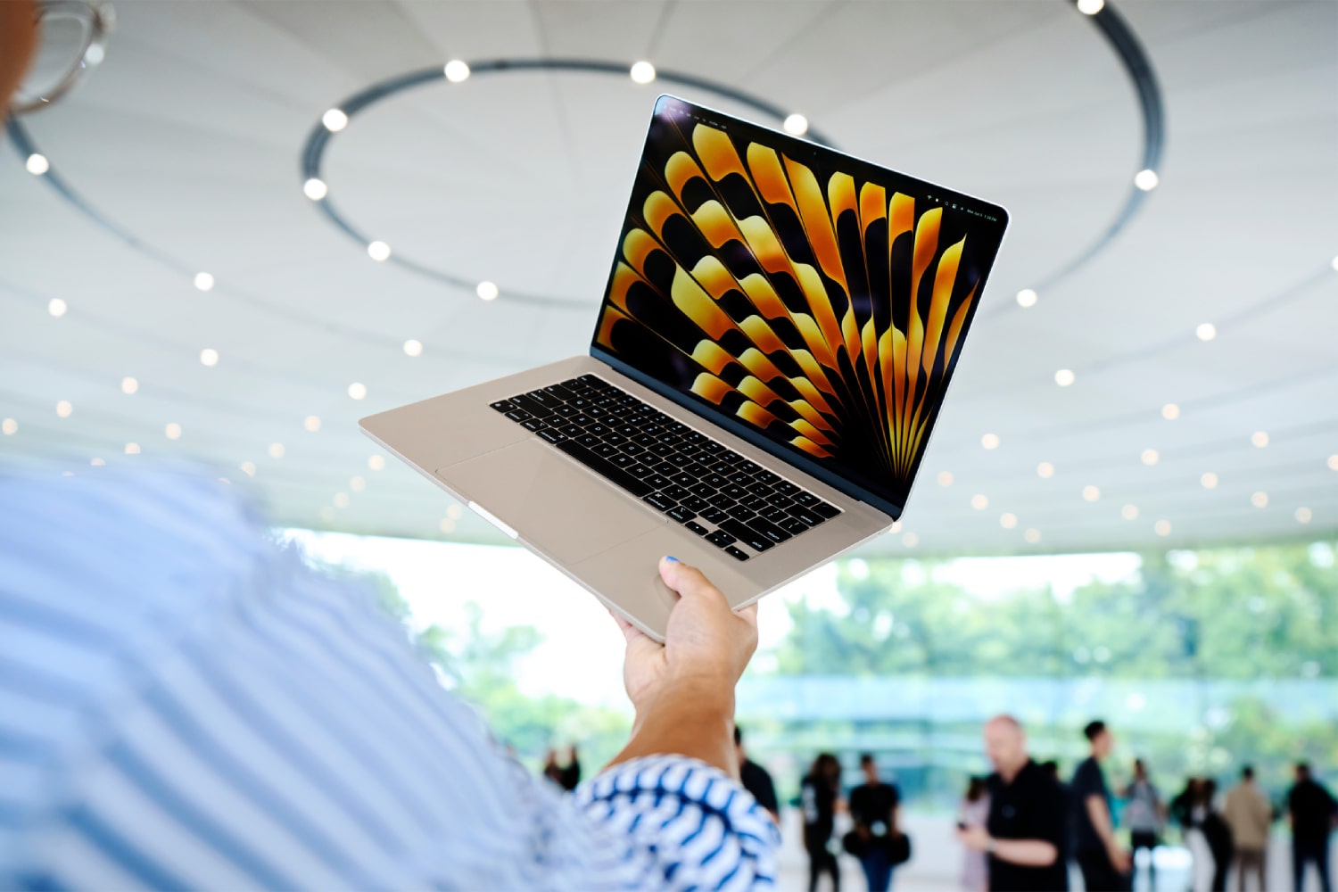 2023 年苹果全球开发者大会 (WWDC) 上，一个人拿着 MacBook Air。