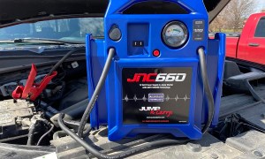 The Clore Jump-N-Carry JNC660 portable jump starter connected to a truck battery.