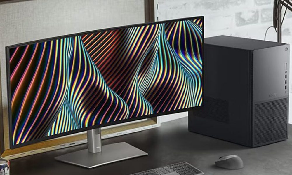 The Dell XPS Desktop on a desk placed next to a curved monitor.