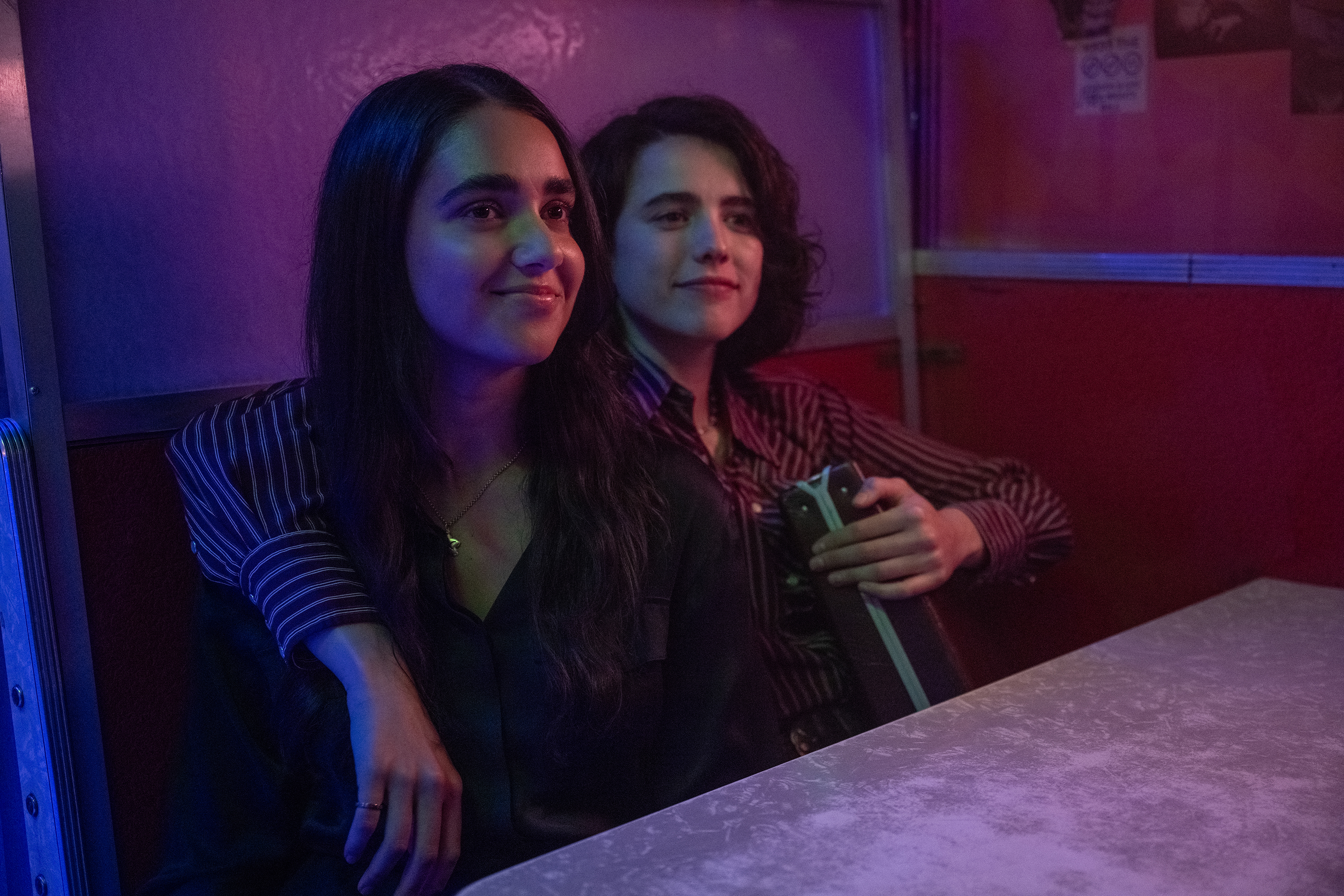 Geraldine Viswanathan et Margaret Qualley tiennent une mallette et l'une l'autre dans une photo de Drive-Away Dolls