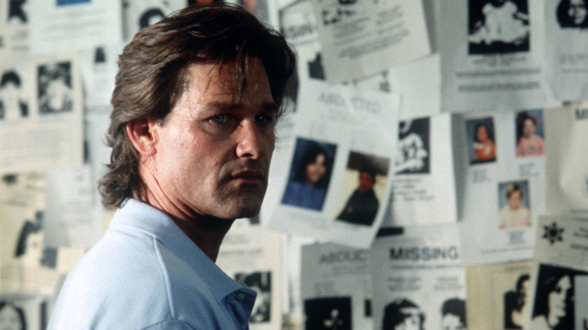 Kurt Russell avec un tableau d'affichage derrière lui dans "Breakdown".