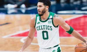 Jayson Tatum dribbles a ball on a basketball court.