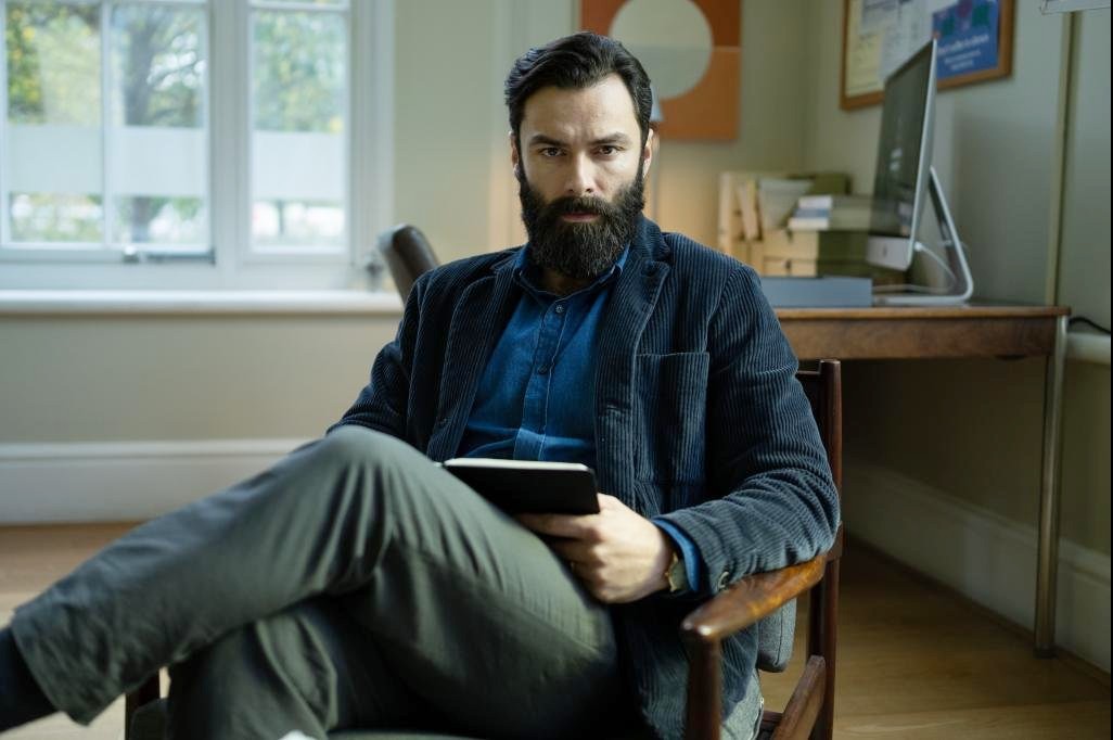 A man sits in a chair in The Suspect.