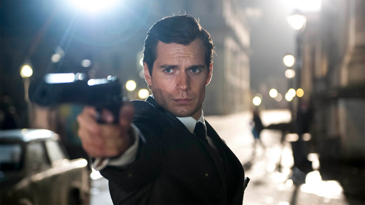 Henry Cavill como Napoleão SOlo apontando uma arma para alguém fora das câmeras em The Man From U.N.C.L.E.