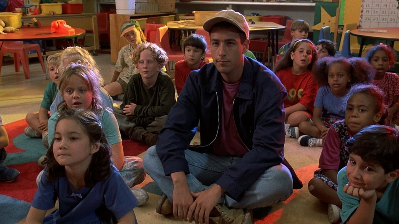 在比利·麦迪逊的场景中，亚当·桑德勒和一群幼儿园的孩子坐在地板上。