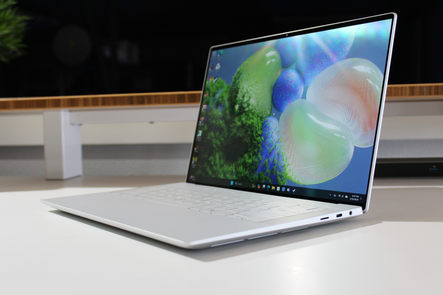 화면이 열려 있는 흰색 테이블 위의 Dell XPS 14.