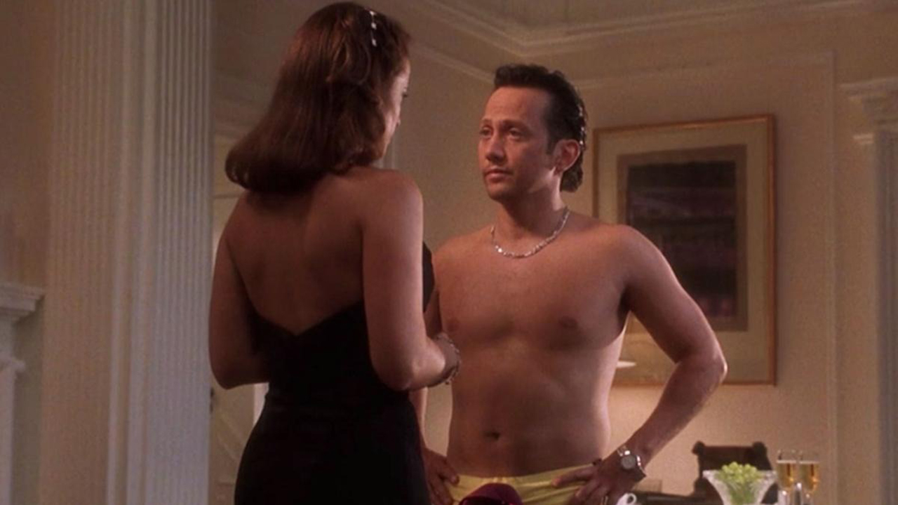 《Deuce Bigalow：男舞男》中的场景中，罗布·施奈德 (Rob Schneider) 赤裸上身站在一名身材更高的女性面前。