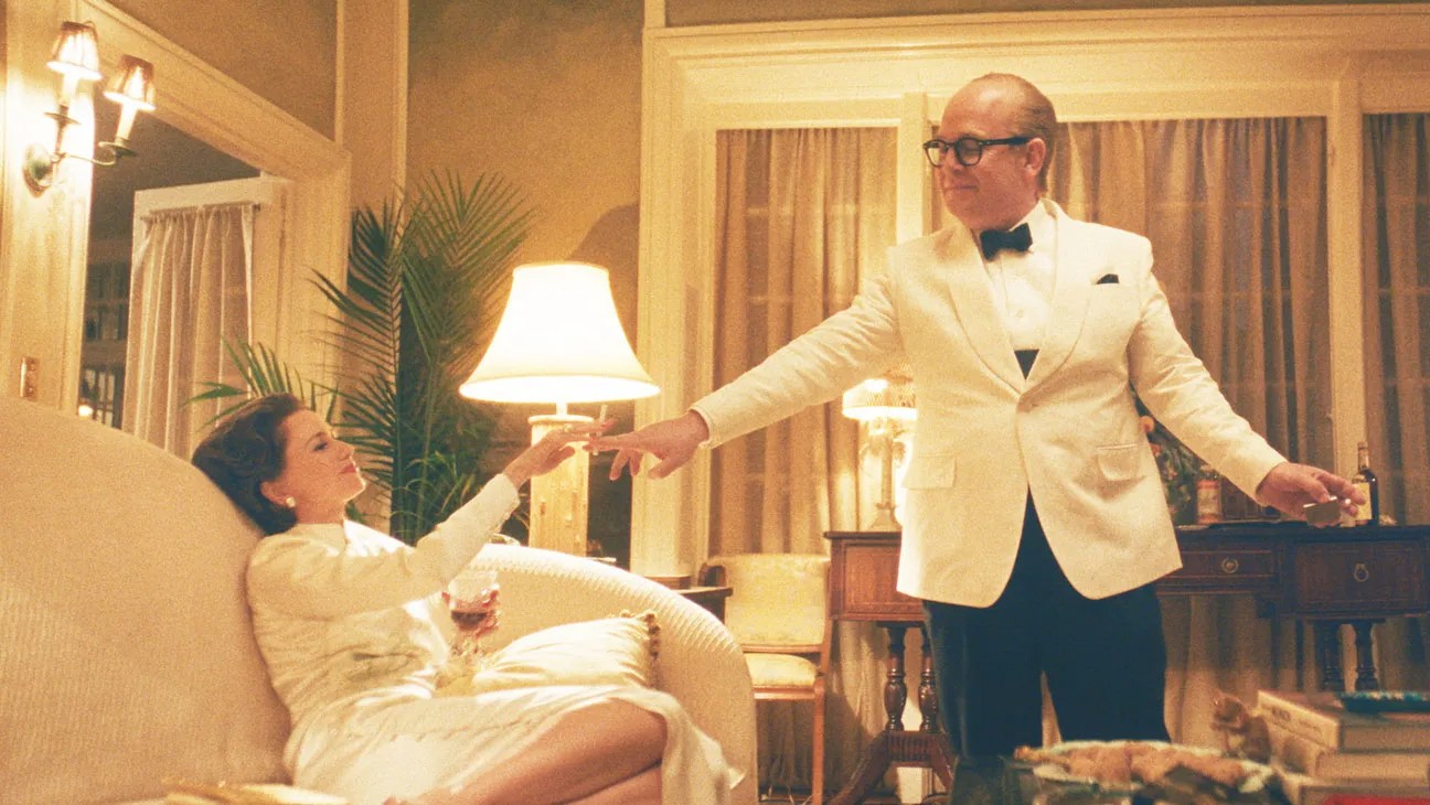 Un homme prend la main d'une femme dans Feud : Capote vs. the Swans.