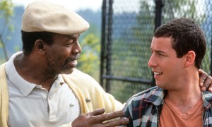 Carl Weathers as Chubbs with his arm around Adam Sandler as Happy Gilmore, the two men looking at one another in a scene from Happy Gilmore.